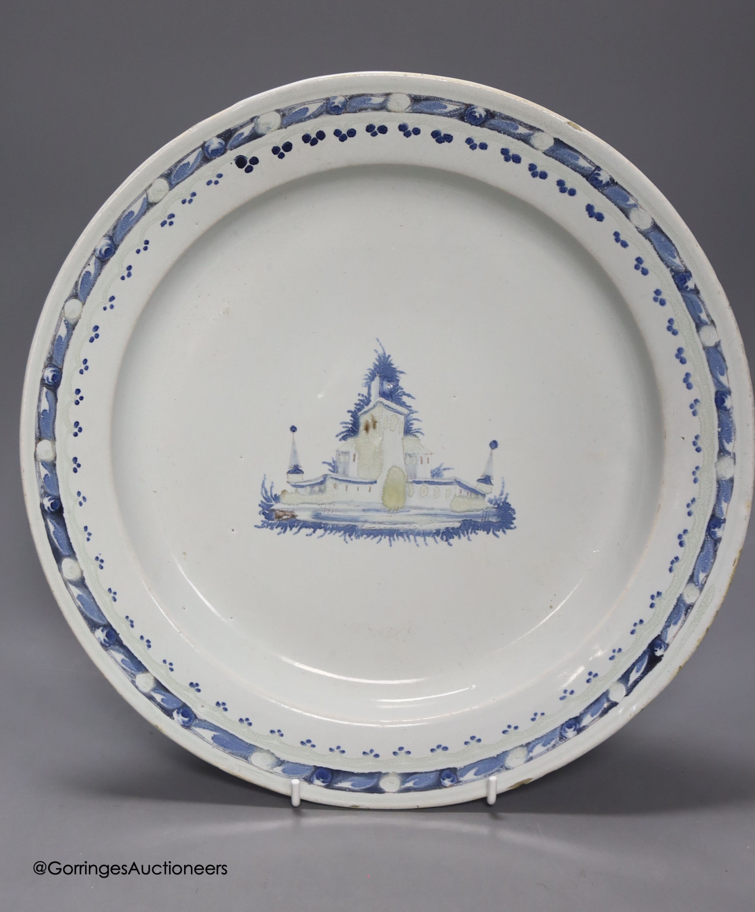 A Continental tin glaze dish, 18th/19th century, possibly Portuguese, a faience Gin barrel, a pottery figure, inscribed in pencil ‘I Barry’ and two Zell Creamware topographical plates